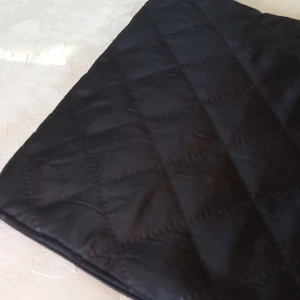 Nytt svart datorfodral - Elegant datorfodral i svart quiltat tyg, svart blixtlås (dragkedja) och svart insida. Yttermått 33 cm × 25 cm. Passar en dator på max 29 cm x 21 cm dvs. en vanlig Chromebook. Datorväskan är oanvänd och unik då jag sytt den. Pris 150 kr + frakt.