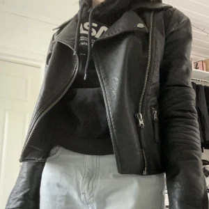 H&M skinnjacka - Skinnjacka från h&m. Så fin till höst och vår! Det ändå som är lite trasigt är i nacken där har en del av ”skinnet” åkt av men inget som syns om man har utsläppet hår eller tröja med luva 💗 den är i storlek XS men skulle säga att det är en XXS