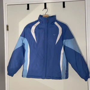 Nike puffer - Blå pufferjacka från Nike med retrokänsla. Fint skick. Står i jackan att den är strl L men passar mig som vanligtvis bär strl XS-S utan att vara oversized, alltså är den liten i storleken. Fraktkostnad kan komma att ändras. Hör av dig vid frågor😊
