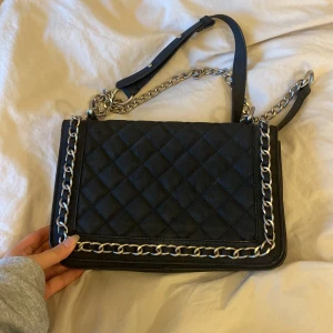 Svart väska Ginatricot - En svart axelremsväska från Gina tricot. Köpt för flera år sedan men i väldigt bra skick! Används tyvärr inte längre.