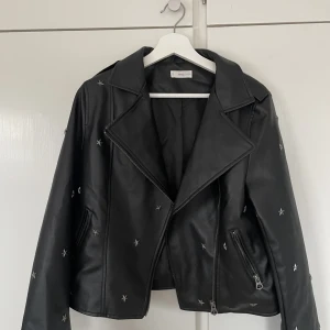 Skinnjacka med stjärnor - Säljer denna coola skinnjacka från Mango med stjärn detaljer. Myxket sparsamt använd och inga defekter. Är i barn storlek 171 men är lika stor som en S 💕💕💕💕