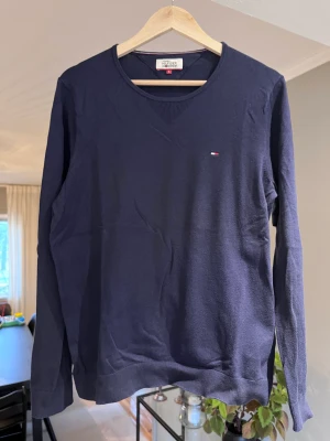 Tröja Tommy Hilfiger - Mörkblå tröja i slimfit från Tommy Hilfiger Denim.  En lite noppra på magen, se sista bilden