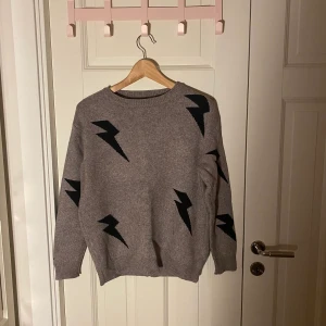 Beige stickad tröja med svarta blixtar - Säljer men fina beiga stickade tröja med svarta blixtar i storlek S för 100kr då jag inte hade någonting till som matchade! Den är använd ungefär 2 gånger och därför i väldigt bra skick! Nypris 220kr, kontakta mig vid intresse! TRYCK EJ PÅ KÖP DIREKT!!!!!