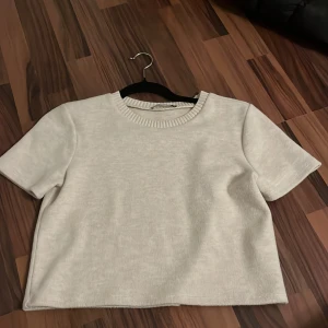 Kort tröja Zara  - Kortärmad beige tröja från Zara (kort i längden), använd ett fåtal gånger så bra skick! 