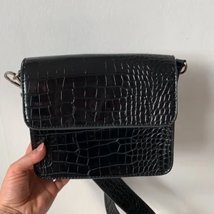 Väska från Hvisk - Jättefin väska från Hvisk. Tyvärr har den gått sönder lite men därför säljer jag den för så bra pris! Nypris är ca 800 kr. H: 18 B: 21 D: 5