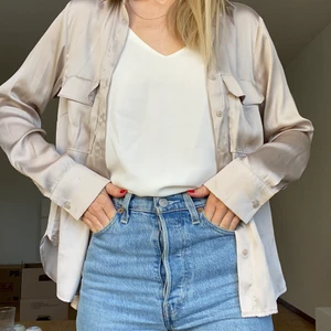 Glansig blus från h&m - En fin blus i en smutsrosa/champagnerosa färg från h&m i storlek 32. 