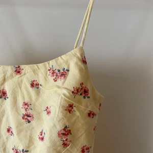 Blommig sommarklänning - Den perfekta sommarklänningen! Ljusgul miniklänning med rosa blommor och spaghettistraps, dragkedja i sidan. Den köptes från asos förra sommaren men kom aldrig till använding för att jag tyckte att den var för kort på mig (är 184cm). Hör gärna av er om ni är intresserade, vill se bilder från andra vinklar eller har andra frågor🌷🌞💕