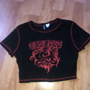 Magtröja  - En svart röd kort armad magtröja 