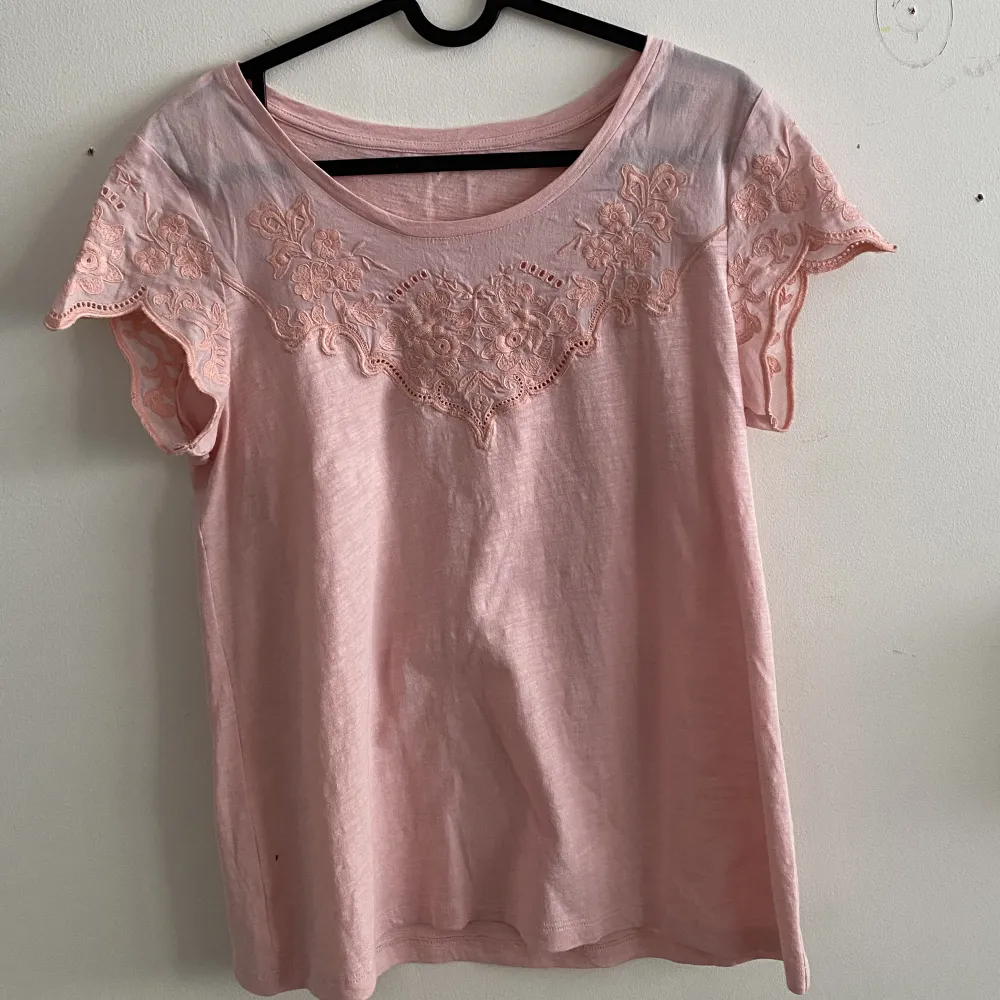 Säljer denna jätte fina ljus rosa T-shirten💞 Det är bomulls material och det är jätte skönt. Den har en fin blomm detalj runt om nacken som går ut i båda armarna🌸 Tröjan har testats av mig en gång Skriv om ni vill ha mera information❤️. T-shirts.