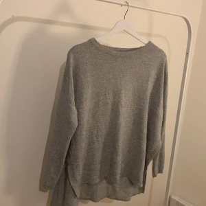 Stickad tröja - En stickad tröja med sidoslits från H&M i storlek M.