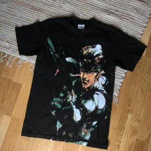 Metal Gear Solid Big Snake T-shirt - MGS-tisha med jumbotryck av Snake. Köpt från USA. Tror inte den går att få tag på längre då det var en pre-order som endast gjordes i få exemplar. Tishan är 6oz så väldigt tjock vilket ger en stabil vintage känsla. Sitter som en S/M