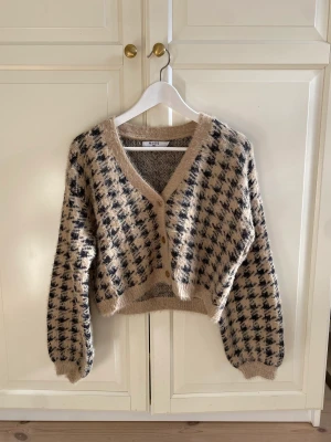 Rutig stickad kofta, NA-KD - Oanvänd beige och svart hundtandsmönstrad stickad kofta. 
