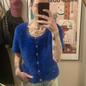 Fluffig 90’s kofta - Mycket mysig kofta-ish i klarblå med knappt fram. Som ny. Den vita pricken som syns på en av bilderna är endast en spegelreflektion. 