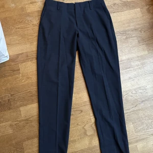 Mörkblå kostymbyxor från Noa Noa - Mörkblå/nästan svarta kostymbyxor i fint material från Noa Noa, använda ett fåtal gånger. Strl 38