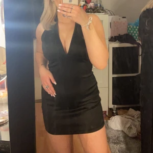 Svart festklänning  - Säljer denna väldigt fina klänning med snörad rygg, den är aldrig använd 