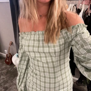 Rutig grön klänning 💚 - Rutig grön off-shoulder klänning från NAKD. Storlek 38. Använd fåtal gånger, bra skick. 💚