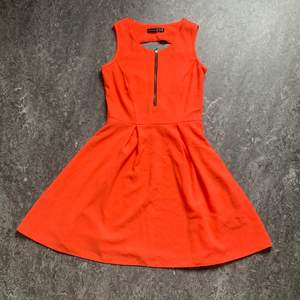 En fin orange klänning i storlek 34. Dragkedja i sidan och en utskärning i ryggen. Frakt tillkommer. 