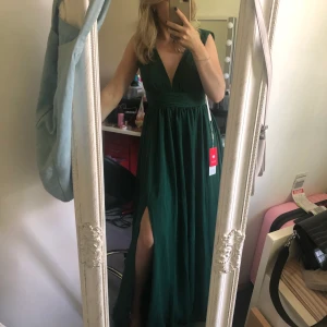 Smaragdgrön långklänning, jjs house - Jättevacker maxiklänning från jjshouse som passar perfekt till bröllop, bal mm. Aldrig använd. Den är i storlek 34 men är som en 36 enligt mig som brukar ha 36 för de mesta. Säljer nu för 1000kr med frakt inräknat, köpte för 1300