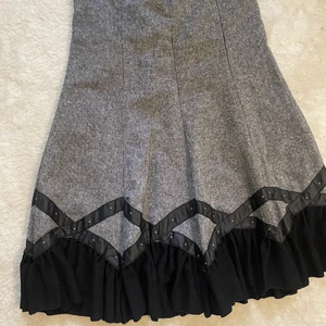 Grå kjol  - En grå ull kjol med svart läder i slutet av kjolen. 