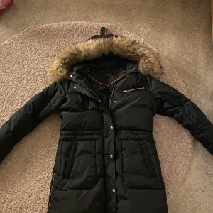Hollies jacka strl 40 - Jackan är köpt för 4 500kr och är använd ett par gånger i vintras. Jackan är i bra skick och värmer så otroligt. Dock så är dragkedjan till dekorationsfickan längst upp lite sönder. Jackan är äkta :)