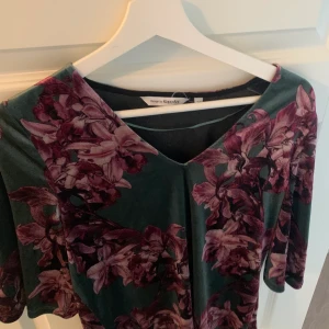 Kappahl sammet tröja  - Mjuk dammet tröja från Kappahl som är V-ringad. Fint skick utan defekter. Bara använd lite.  Gina blommor och grön bakgrund🍀🎀 