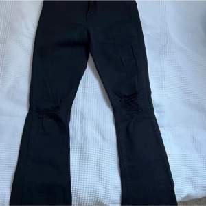 Svarta flared jeans med en slitning vid knäna, säljer de för de är för små för mig✨