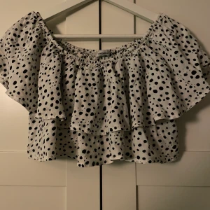 Topp från Chiquelle  - En fin kortare modell från Chiquelle, fin till alla underdelar både kjol men även till kostymbyxor te.x. Skönt och lätt material, volang likt där tyget går omlott som ni ser i fram