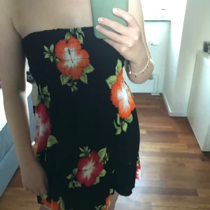 Klänning - En svart klänning med blommor. Passar XS/S. Är i mycket bra skick.