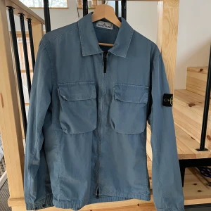 Stone island jacka  - Äkta Stone island jacka inköpt från NK i Stockholm för cirka 6 månader sedan. Säljes på grund av att den inte kommer till användning. Jackan är tunn men den håller dig varm med en tröja under. Passar dom som är upp till 185cm. Original pris 3600kr men säl