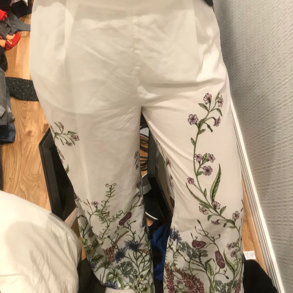 ett par jätte fina vit/blommiga byxor från bikbok i storlek S. Jeans & Byxor.
