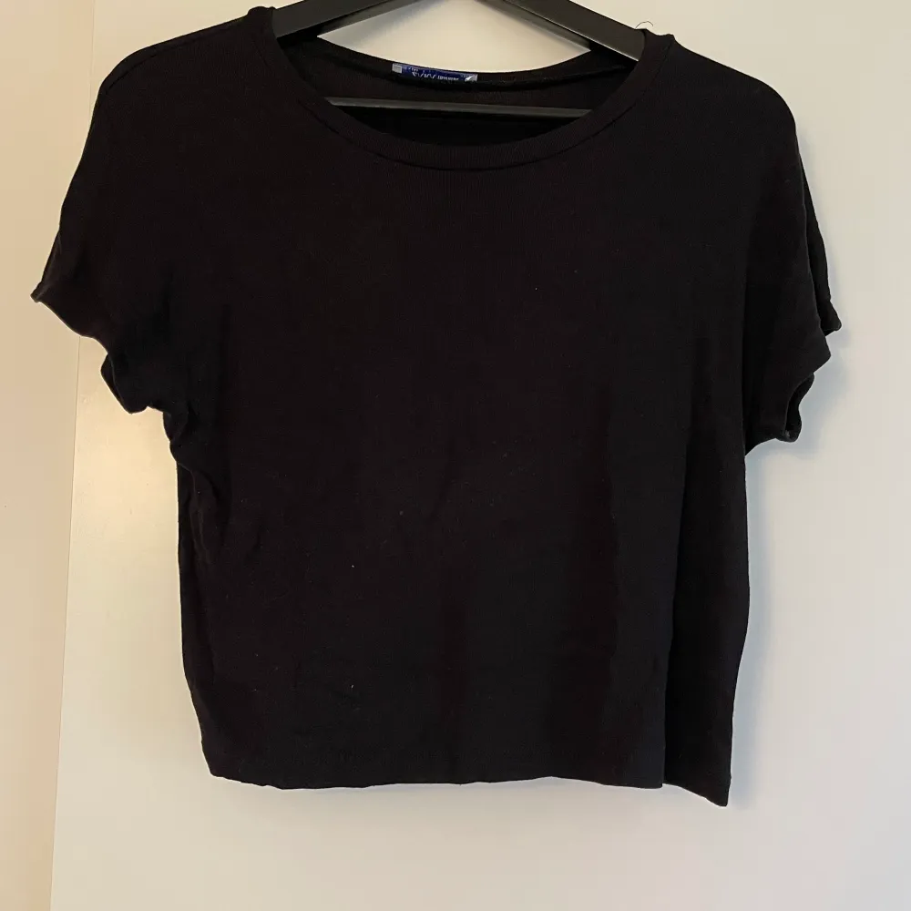 Svart Crop Top T-shirt från Zara i storlek L, ganska liten i storleken. Nyskick. T-shirts.