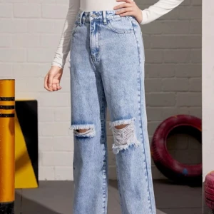 Ljusblå högmidjade jeans - Ljusblå jeans med hål vid knäna från SHEIN. Hålen har förstorats lite men annars är dom fina.