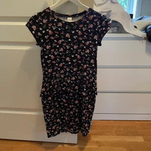 Klänning, Lindex, blommor, sommar, gullig  - En blommig klänning med en liten volang från Lindex. Storlek 146-152