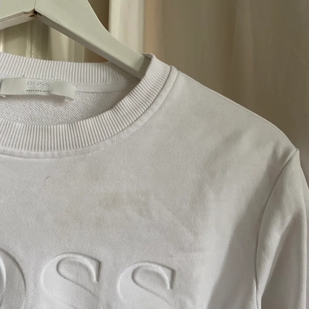 Vit Hogo Boss sweatshirt i storlek xs, köpt på room 1006 i emporia. Kommer tyvärr inte till användning längre. Har en fläck som man kan se på andra bilden. Därav ett lägre pris 🤍🤍🤍. Tröjor & Koftor.