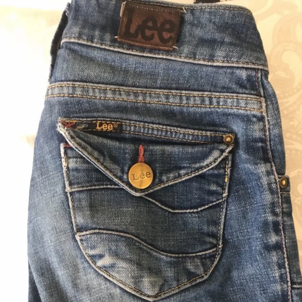 Jättesnygga lågmidjade jeans från Lee, köpta på secondhand. Mjuka, snygga och trendiga, men en knapp saknas på backfickan (det tänker man inte på) så det drar ner priset. Det vita i färgen på byxorna är hur de är gjorda, inte slit🥰 Gissar på S, de passar mig som har S-M 💕 (Skriv för fler bilder❤️) . Jeans & Byxor.