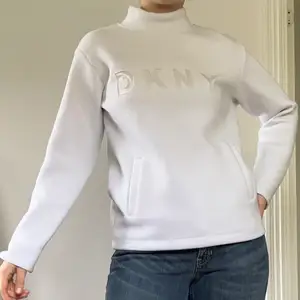 Cool och lite futuristisk pullover utan hoodie från DKNY! Den har en liten fläck på framsidan (se bild 3), men den syns knappt. Det står XXS på taggen men passar som en kvinnlig M! Köparen står för frakt!☺️