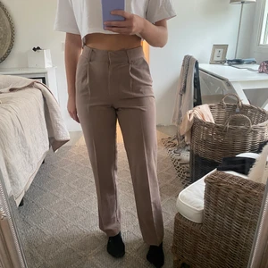 NAKD kostymbyxor - Brun/beiga kostymbyxor, knappt använda från NAKD. Är i storlek 34.