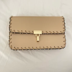 Väska - En jättefin guldfärgad clutch från Zara med detaljer. Innuti finns utrymme för kort m.m. Köptes för 399 kr men säljer för 100 kr. Pris kan diskuteras💓