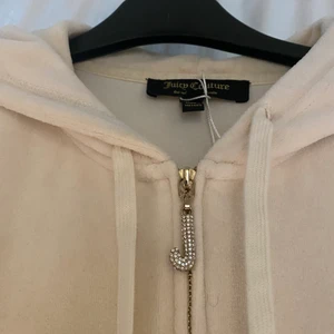 Juicy couture kofta - jätte fin och eftertraktad juicy couture hoodie i en vintage modell med fina detaljer på dragkedjan. Den är krämvit färg om det är otydligt på bilden och den är strl L men väldigt liten i storleken så skulle mer säga Xs/s. Köpt på SELLPY !!