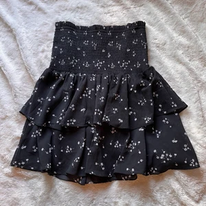 Svart kjol med blommor  - Säljer denna svarta kjol med vita blommor från Cubus. Har knappt använt den så är i bra skick🌸 Har ni några frågor så kontakta mig<33