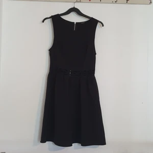 Svart klänning med detalj i midjan från HM  - Sparsamt använd