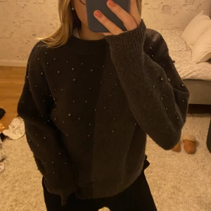 Stickad tröja  - Mörkgrå stickad tröja med pärlor på från h&m. Superfin och skön men kommer tyvärr inte till användning. Storlek xs, säljer för 100kr + frakt