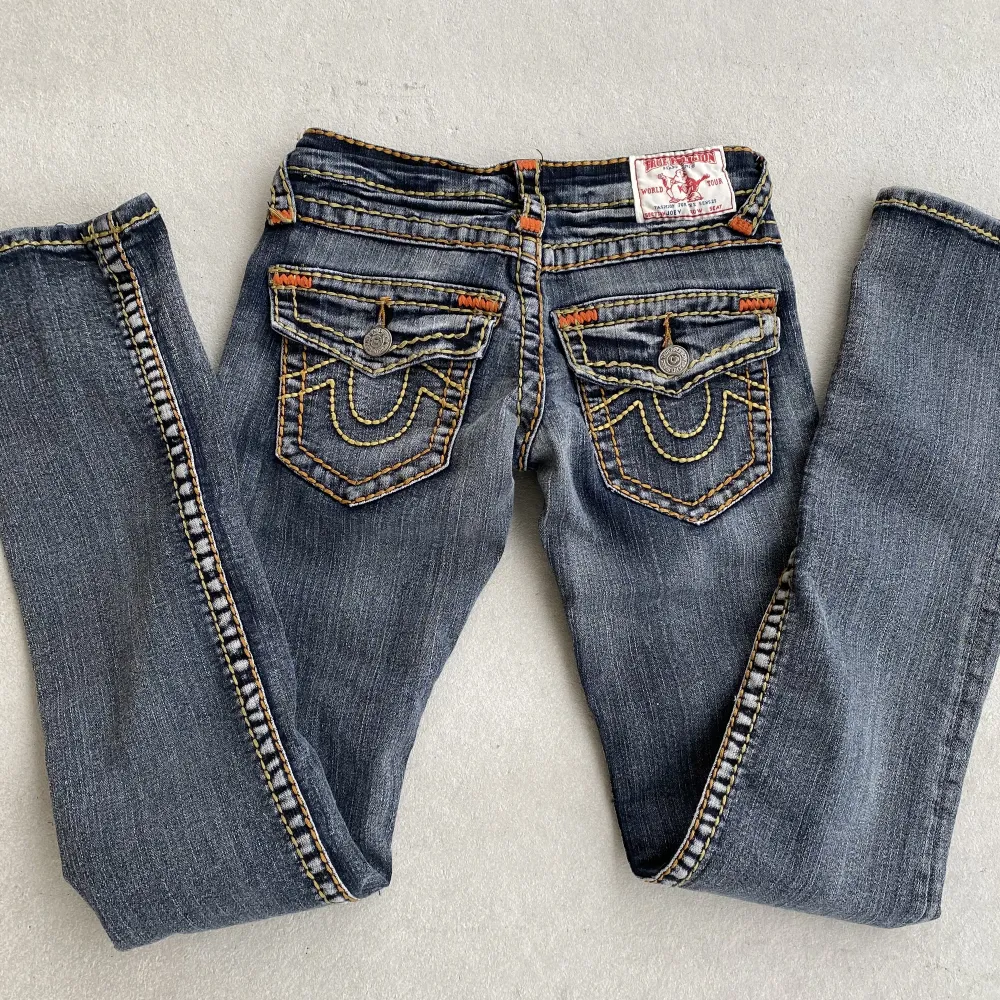 gråa jeans i modellen Joey från true religion. gula och orangea sömmar❤️‍🔥 skulle säga att dom är som xs/xxs i storleken. för korta på mig som är 173. MÅTT: midjemått rakt över: 30 cm, låret rakt över: 20cm, innerbenslängd: 75cm. obs! skickas tidigast 23/2. Jeans & Byxor.