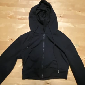 Kort huvtröja - En kort huvtröja i färgen svart 