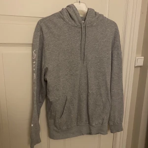 Hoodie från H&M  - Säljer denna basic hoodie med tryck på ärmarna från H&M. I fint skick. Med luva. Fickor framtill. Storlek på XS. 78% bomull, 18% polyester och 4% viskos.