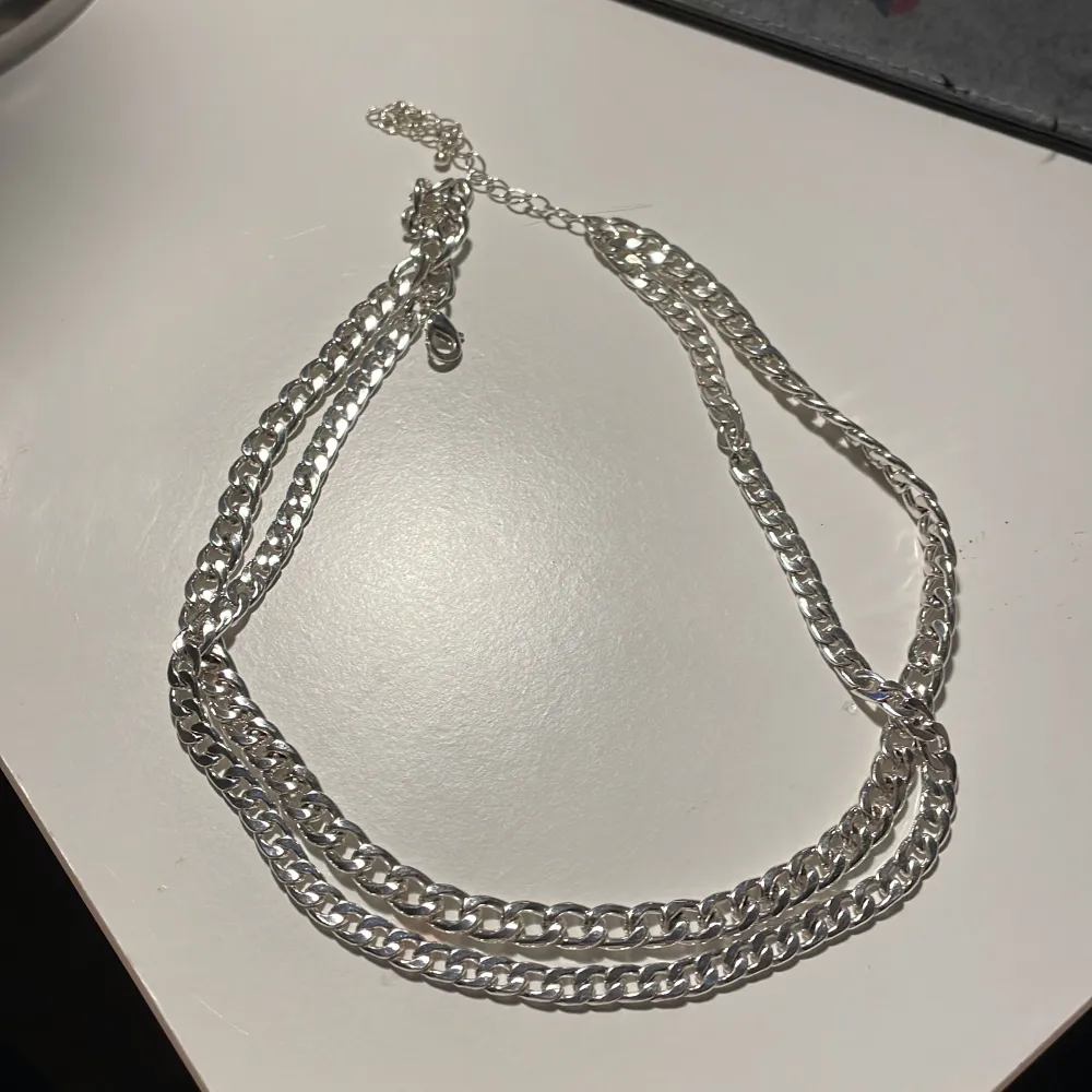 Silvrigt halsband som ser ut som 2 stycken . Accessoarer.