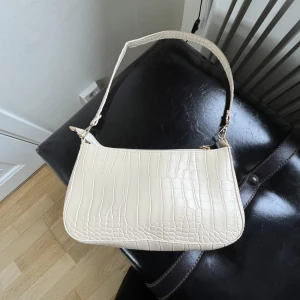 Väska - En fin axelväska i färgen beige. 