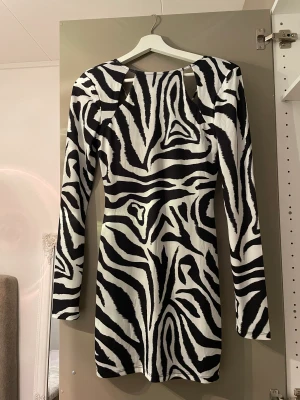 Miniklänning med utskurna partier - Helt oanvänd miniklänning från NA-KD. Utskurna partier i fram och öppen rygg. Säljer pga aldrig kommit till användning