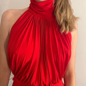 Röd jumpsuit - Röd jumpsuit med halterneck, vida ben och öppen rygg. Verkligen ett statement kort! Stretchig i tyget så passar flera storlekar. För referens är jag 170cm lång och har normalt sett 38 ❤️ Använd 1 kväll.