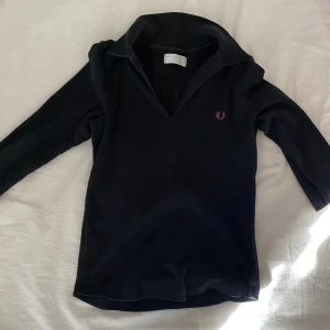 Fred Perry tröja - Fred Perry tröja med trekvarts ärmar, polo krage och rosa broderat märke. Använd gärna köp nu 💋